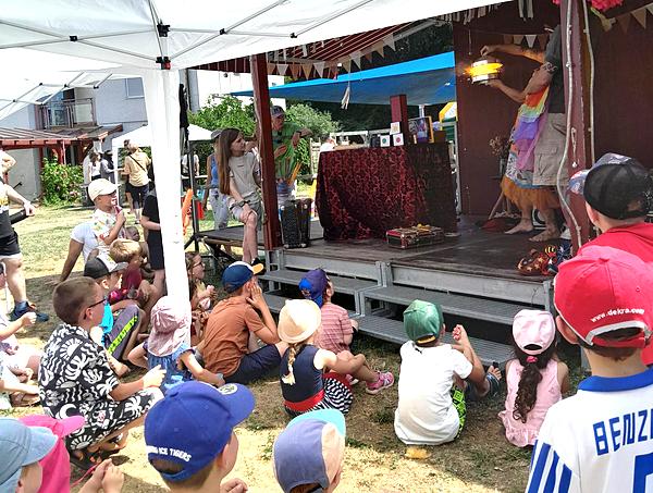 Bühne vor der Kinder sitzen und dem aufgeführten Theater zuschauen
